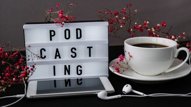 podcasting lettering with headphones and mobile phone